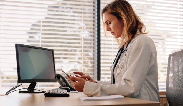 Female doctor using computer and phone