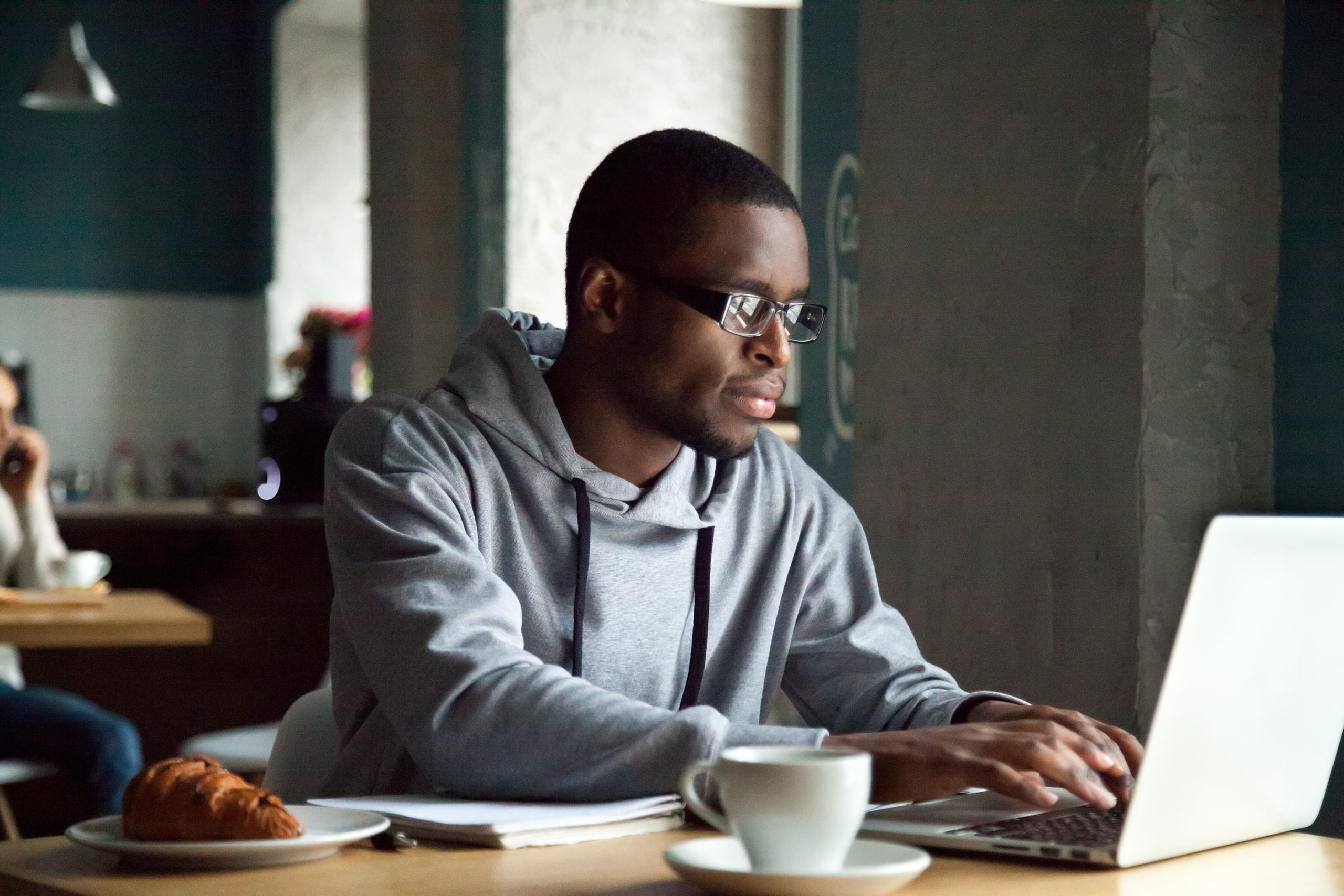 Man using laptop in a cafe