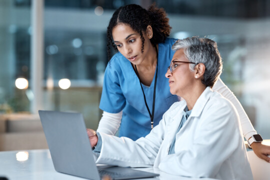 Two female doctors discussion by laptop