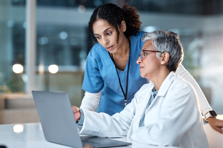 Two female doctors discussion by laptop