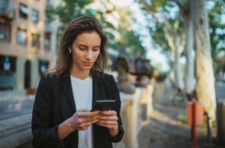 Businesswoman standing outdoors with mobile