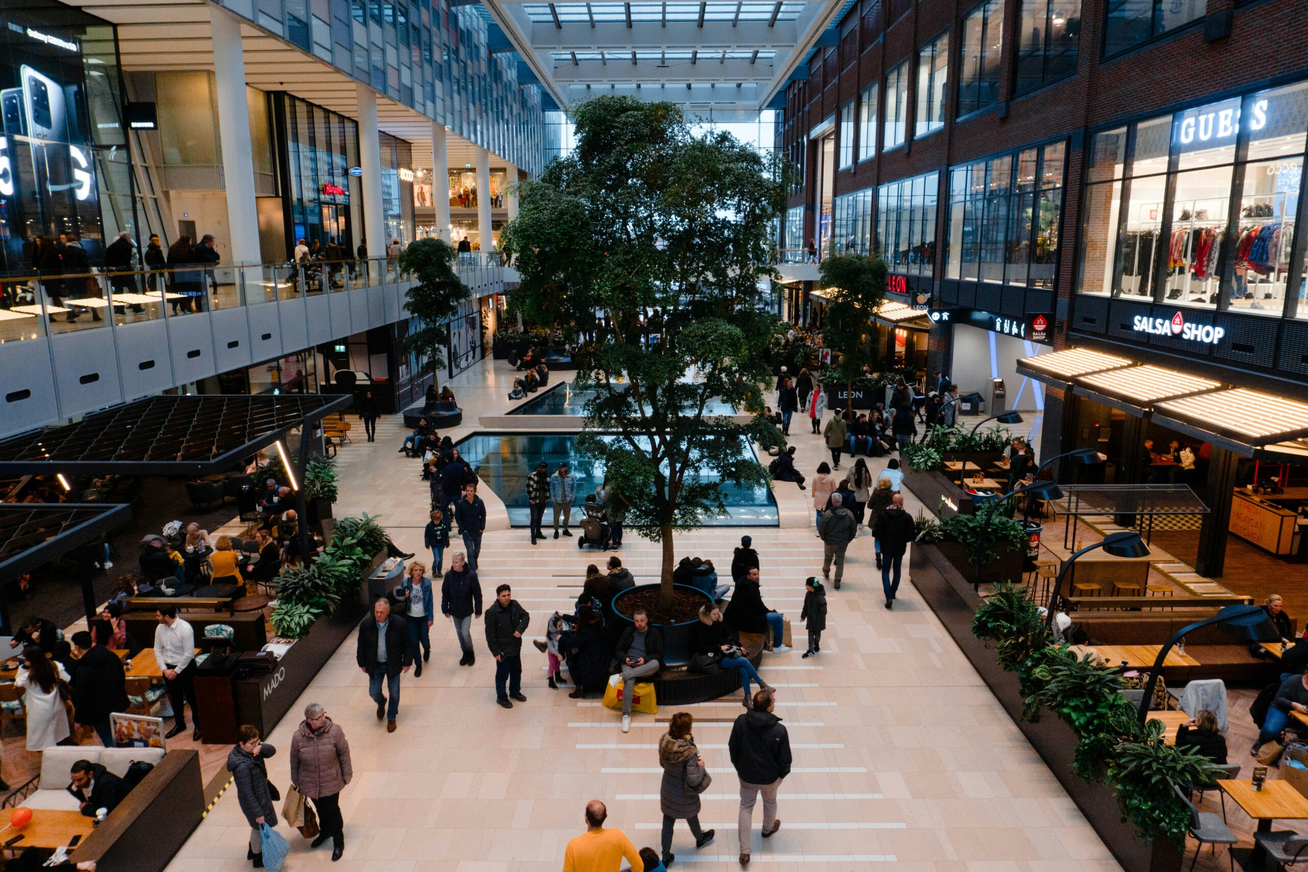 crowd of people in a shopping mall, the real-time economy